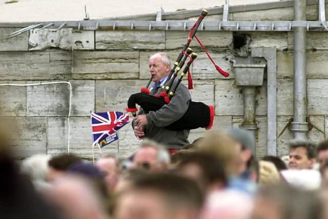 A lone piper plays in HMS Ark Royal as she is welcomed  back to Portsmouth Harbour by huge crowds along the water front..PICTURE: IAN HARGREAVES.  (032434-3)