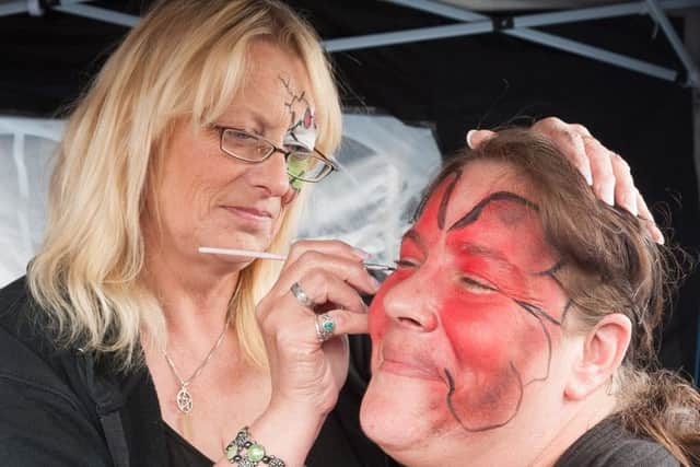 Cat Farley paints a design on Emma Hider Picture: Keith Woodland (160949-023)