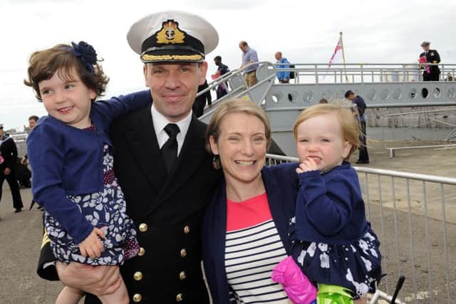 Commanding Officer of HMS Iron Duke Commander Ben Aldous holding his eldest daughter Mia, three, and his wife Kate with Isla, two Picture: Malcolm Wells (160707-4867)