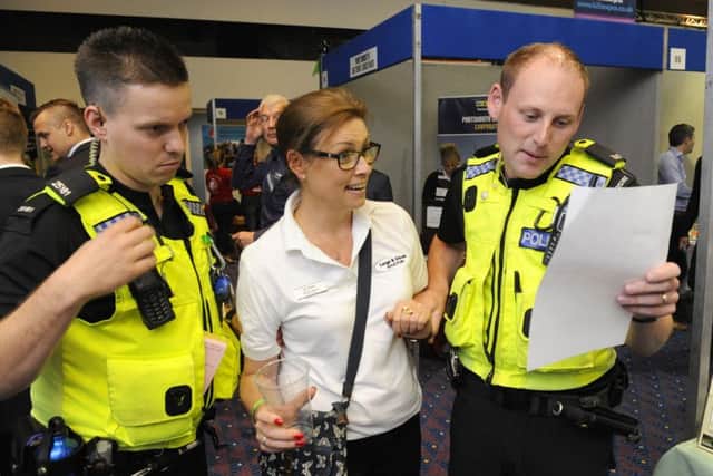 Rachel Harvey, the office manager for Large & Gibson Solicitors was 'arrested' by police officers PC Dane Millerchip, left, and PC Dan McGarrigle at The Pyramids Portsmouth Business Expo to raise funds for The Elizabeth Foundation
Picture: Malcolm Wells (160707-4966)