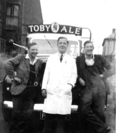 Alfred Ware, in the white coat, in front of a Charringtons lorry in the 1950s