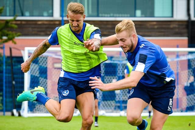 Jack Whatmough, right, gets to grips with new Pompey team-mate Carl Baker   Picture: Colin Farmery