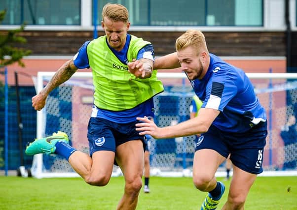 Jack Whatmough, right, gets to grips with new Pompey team-mate Carl Baker   Picture: Colin Farmery