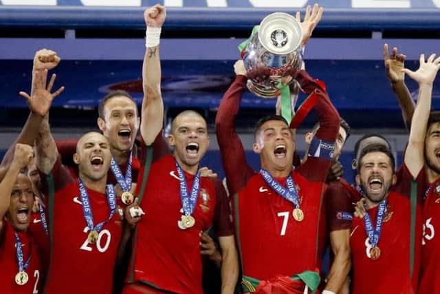 Portugal's Cristiano Ronaldo holds up the trophy at the end of the Euro 2016 final soccer match between Portugal and France.