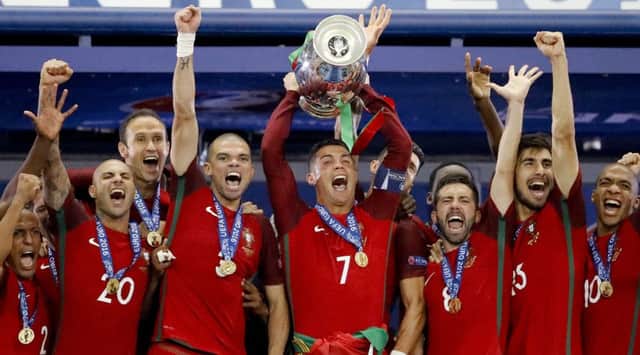 Portugal's Cristiano Ronaldo holds up the trophy at the end of the Euro 2016 final soccer match between Portugal and France.