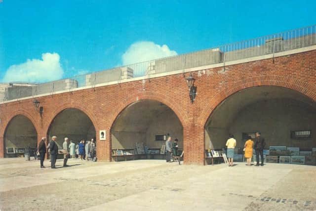 A postcard from the 1970s showing four of the historic arches being used to sell local artists work
