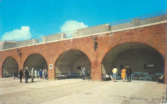 A postcard from the 1970s showing four of the historic arches being used to sell local artists work