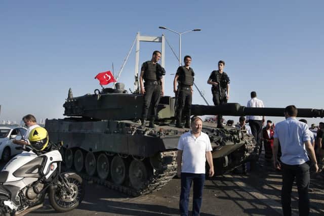 People gather around as Turkish police officers, loyal to the government, stand atop tanks abandoned by Turkish army officers. Picture: AP Photo/Emrah Gurel TURKEY_Coup_083327.JPG