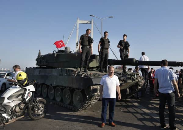 People gather around as Turkish police officers, loyal to the government, stand atop tanks abandoned by Turkish army officers. Picture: AP Photo/Emrah Gurel TURKEY_Coup_083327.JPG