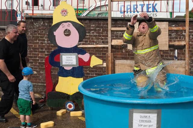Anthony Russell, Watch Manager at Cosham fire station gets dunked by Rupert Knighton-Callister, 3 whose great grandfather was a fireman at Cosham. Picture Credit: Keith Woodland
