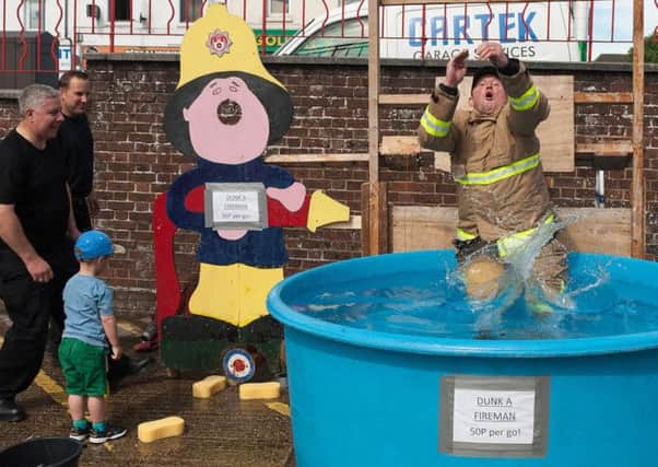 Anthony Russell, Watch Manager at Cosham fire station gets dunked by Rupert Knighton-Callister, 3 whose great grandfather was a fireman at Cosham. Picture Credit: Keith Woodland