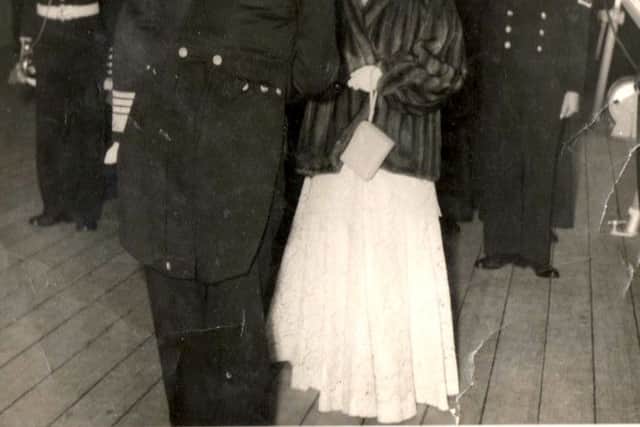 On what must have been a very cold evening we see HM Queen Elizabeth being greeted on arrival on board HMS Vanguard.