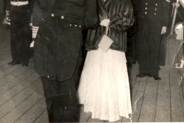 On what must have been a very cold evening we see HM Queen Elizabeth being greeted on arrival on board  HMS Vanguard.