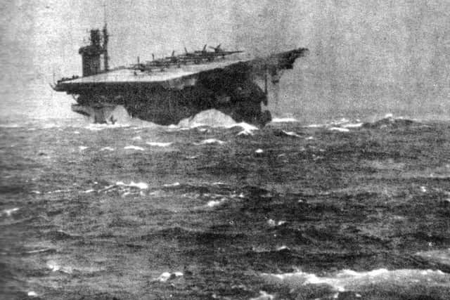 HMS Biter, tossed like a cork, ploughs through rough seas in 1943. Six Seafires are secured on her flight deck