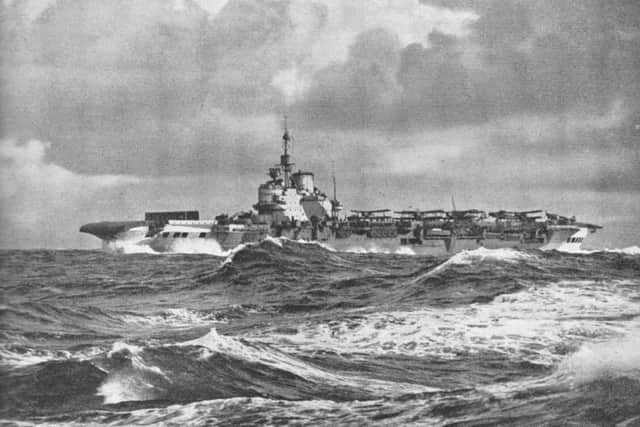 The legendary HMS Victorious under stormy skies in 1943. The black shield forard is a wind barrier to protect the aircraft.
