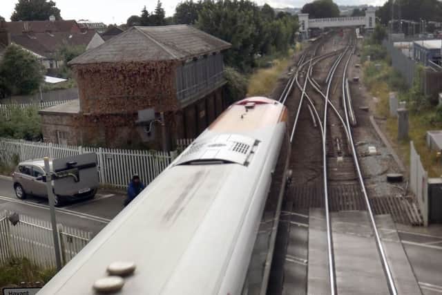 The same view today with a modern train from Waterloo passing the decommissioned signal box