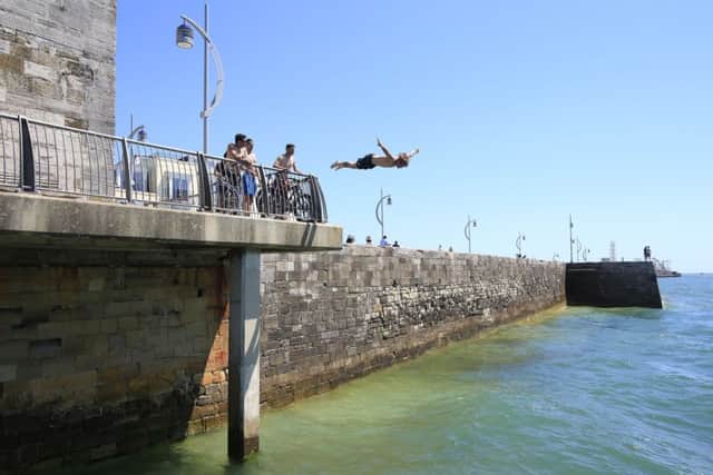 A man dives off of the sea wall near Old Portsmouth, as Britain has sweltered on the hottest day of the year so far, with soaring temperatures sparking a surge in calls for medical help and causing delays on the railway. PRESS ASSOCIATION Photo. Picture date: Tuesday July 19, 2016. Temperatures reached 32.2C (89.9F) at Brize Norton on Tuesday afternoon, the Met Office said, with the mercury predicted to reach 35C (95F) by the end of the day - making it hotter than Barcelona. See PA story WEATHER Hottest. Photo credit should read: Jonathan Brady/PA Wire WEATHER_Hottest_153741.JPG