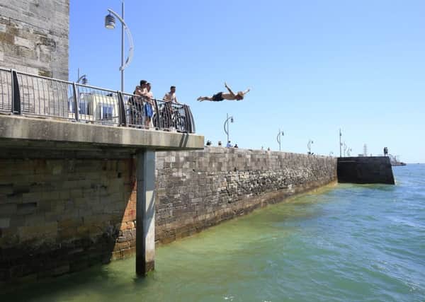 A man dives off of the sea wall near Old Portsmouth, as Britain has sweltered on the hottest day of the year so far, with soaring temperatures sparking a surge in calls for medical help and causing delays on the railway. PRESS ASSOCIATION Photo. Picture date: Tuesday July 19, 2016. Temperatures reached 32.2C (89.9F) at Brize Norton on Tuesday afternoon, the Met Office said, with the mercury predicted to reach 35C (95F) by the end of the day - making it hotter than Barcelona. See PA story WEATHER Hottest. Photo credit should read: Jonathan Brady/PA Wire WEATHER_Hottest_153741.JPG