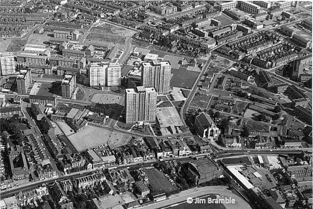 All Saints Church, Landport, is featured in this picture, dwarfed by the tower blocks behind it. Commercial Road runs across the picture still lined by shops and houses. The M275 was yet to be built