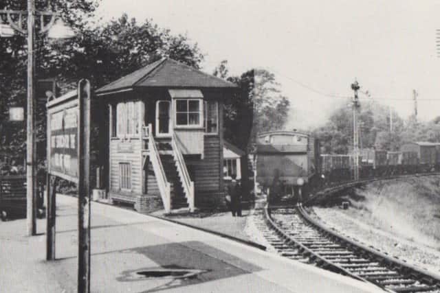 Passing the signal box, a train from the dockyard passes the home signal and comes onto the main line at Portsmouth & Southsea High Level.