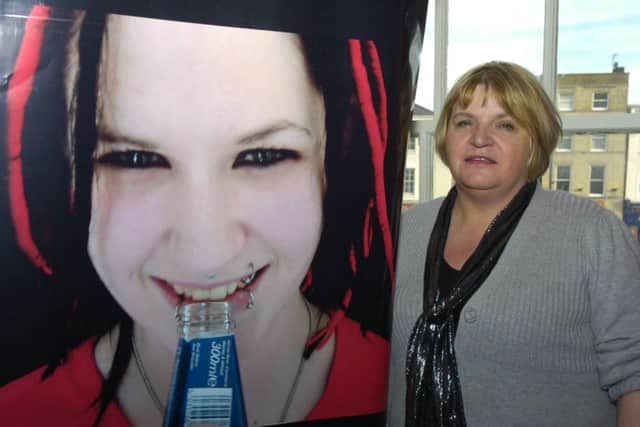 Sylvia Lancaster with a poster of her daughter, Sophie, whose murder prompted the creation of the SOPHIE Lancaster Foundation