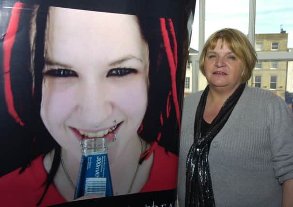 Sylvia Lancaster with a poster of her daughter, Sophie, whose murder prompted the creation of the SOPHIE Lancaster Foundation