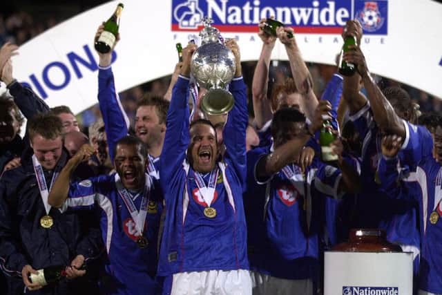 Paul Merson leads the celebrations at Fratton Park by lifting aloft the Division One championship trophy after victory against Rotherham Picture: Steve Reid