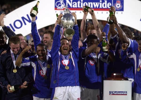Paul Merson leads the celebrations at Fratton Park by lifting aloft the Division One championship trophy after victory against Rotherham Picture: Steve Reid