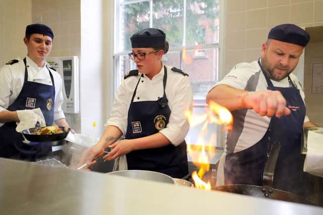 From left, Leading Chef James Lloyd and Chef Grace Threapleton, from team HMS Queen Elizabeth, competing against Petty Officer (Catering Services) Sid Wilkins from team Retinue Support Pool during Cook & Serve Picture: LPhot Paul Hall