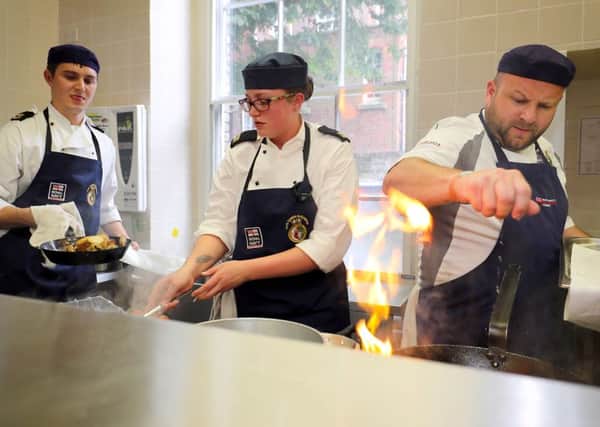 From left, Leading Chef James Lloyd and Chef Grace Threapleton, from team HMS Queen Elizabeth, competing against Petty Officer (Catering Services) Sid Wilkins from team Retinue Support Pool during Cook & Serve Picture: LPhot Paul Hall