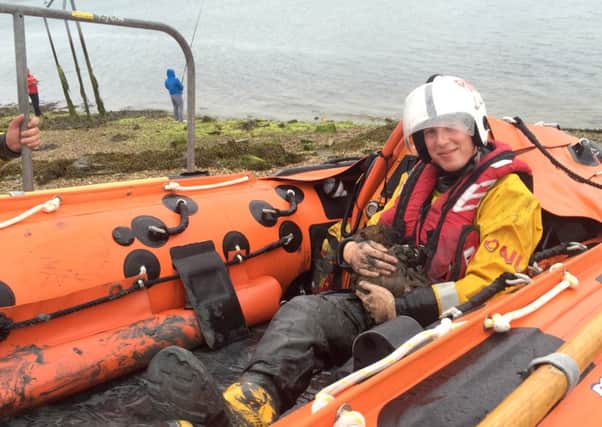 Josh in the D-Class Lifeboat cradling Minnie Mouse to keep her warm Picture: RNLI