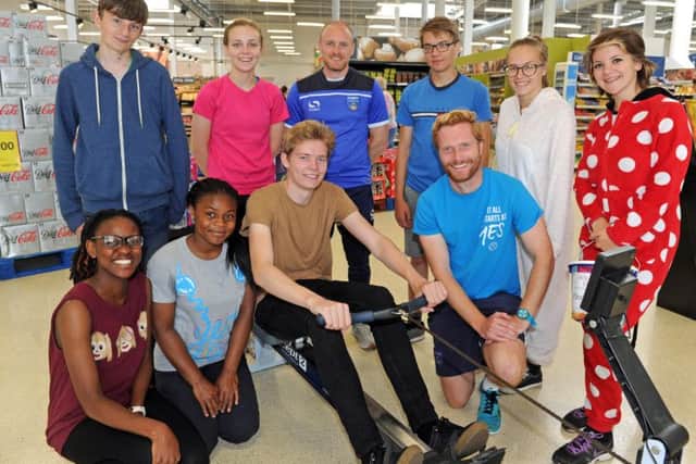 The NCS rowathon at Tesco in Fratton which raised money for the Help 4 Special Children charity. Dan Rook and Adam Browne from Pompey In The Commiunity and students look on as student Calum Jackson, 17, starts his session.Picture: Ian Hargreaves (161088-1)