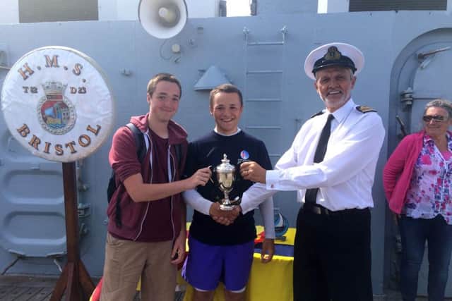 From left, Tom Wilkinson and Frank Leslie receive the HMS Bristol Trophy from Lieutenant Commander David Price, the Commanding Officer of HMS Bristol