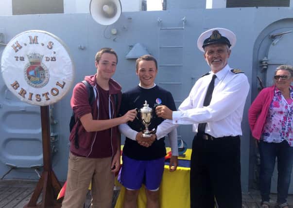 From left, Tom Wilkinson and Frank Leslie receive the HMS Bristol Trophy from Lieutenant Commander David Price, the Commanding Officer of HMS Bristol