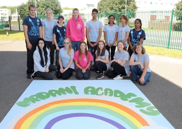 Children on the National Citizen Service helped out at the Madani Academy in Portsmouth. Team leader Hannah Daniels - in the front row, wearing pink - with the mural the children created						      Picture: Sarah Standing (161120-784)
