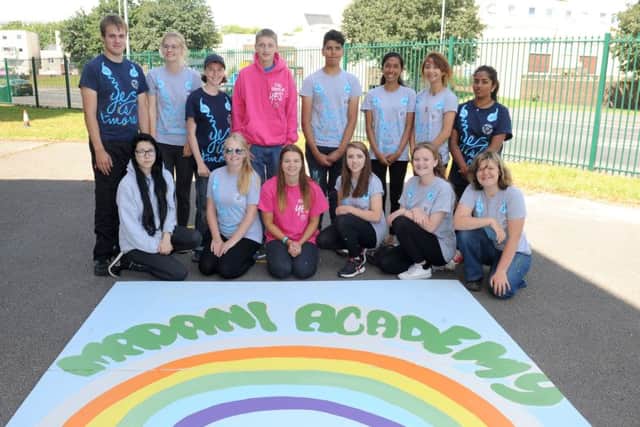 Children on the National Citizen Service helped out at the Madani Academy in Portsmouth. Team leader Hannah Daniels - in the front row, wearing pink - with the mural the children created Picture: Sarah Standing (161120-784)