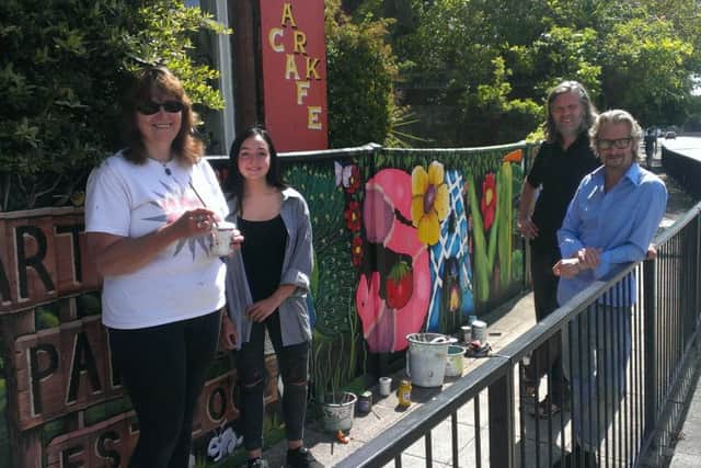 From left, volunteer artists Lorrie Slee and Serena Wild, Ben Baxter of Broken Republic and Lodge Arts Centre owner Mark Lewis, next to the new Save the Lodge mural