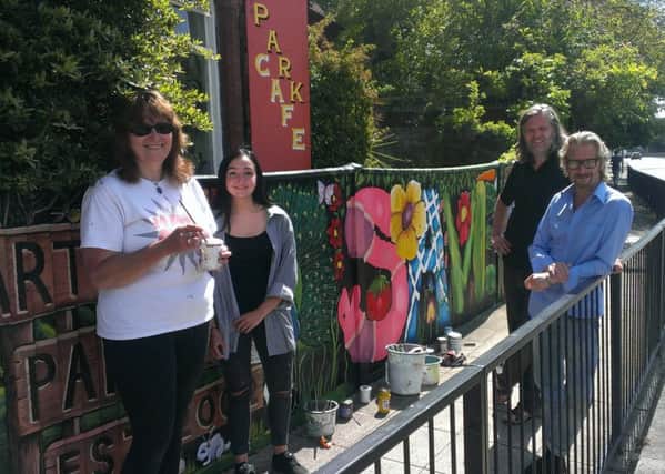 From left, volunteer artists Lorrie Slee and Serena Wild, Ben Baxter of Broken Republic and Lodge Arts Centre owner Mark Lewis, next to the new Save the Lodge mural