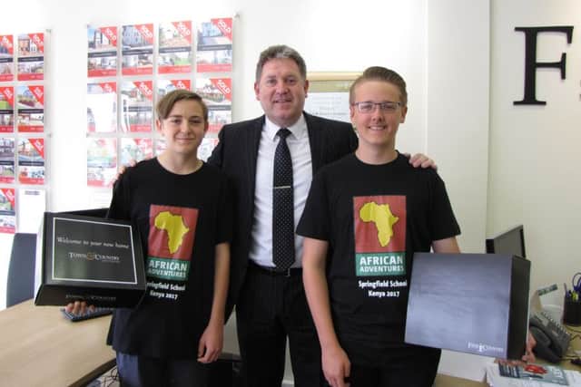 Jack Ancell, left, and Joseph Bunnage, right, receive their raffle prizes from Colin Shairp, who has also offered the pair an auction lot of a house sale for free