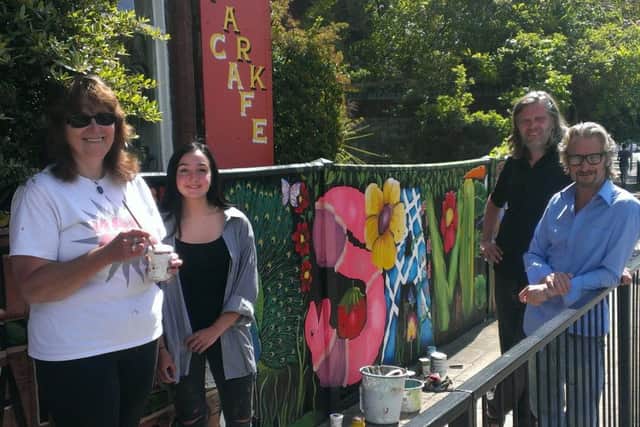 From left, volunteer artists Lorrie Slee and Serena Wild, Ben Baxter of The Broken Republic and Lodge Arts Centre owner Mark Lewis, next to the new Save the Lodge mural alongside The Lodge in Victoria Park