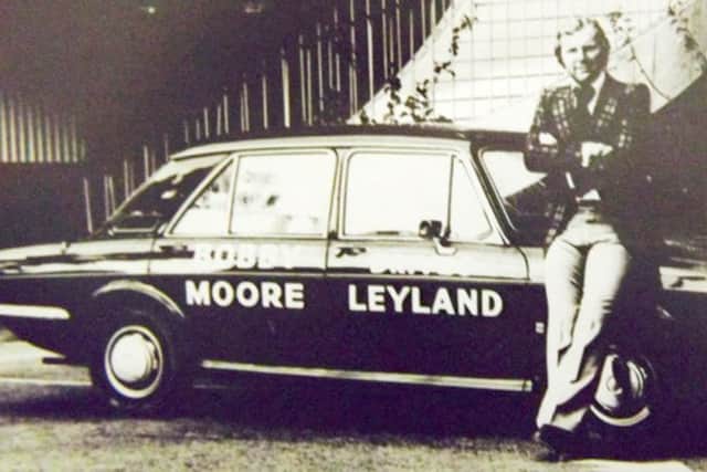 Bobby Moore poses with a car loaned to him by Joe McCue.