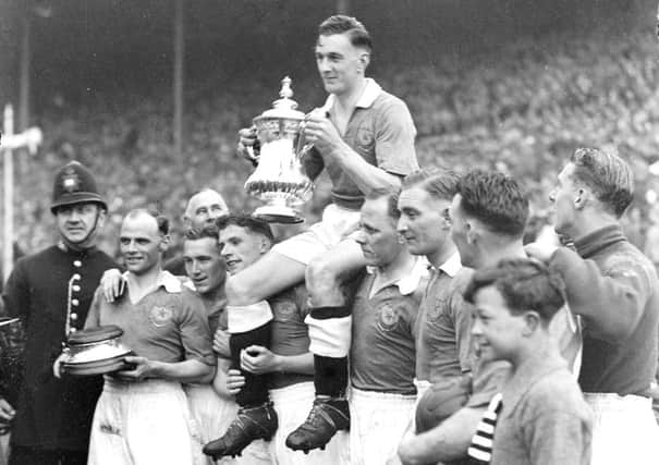 Pompey captain Jimmy Guthrie is held aloft with the FA Cup