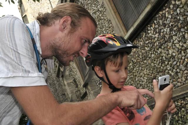 Daniel Davis and son Sidney, six, get involved in catching pokemon characters Picture Mick Young (161078-01)
