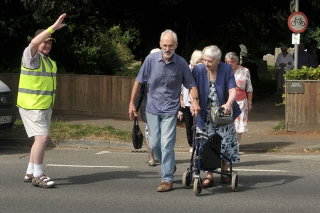 'Lollipop man Jim Burgess guides church congregation members across the road at St Mary's Church, Hayling Island 
Picture: Mick Young
 (161076-02)
