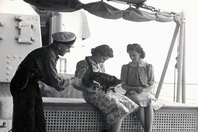 Princess Elizabeth with Minnie the dining hall cat, 1947. Picture: John Hucker.