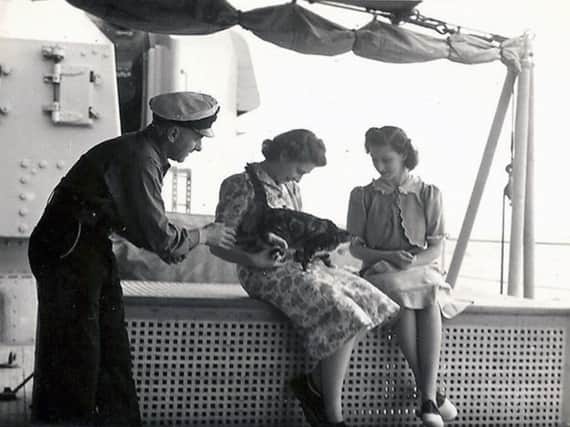 Princess Elizabeth with Minnie the dining hall cat, 1947. Picture: John Hucker.