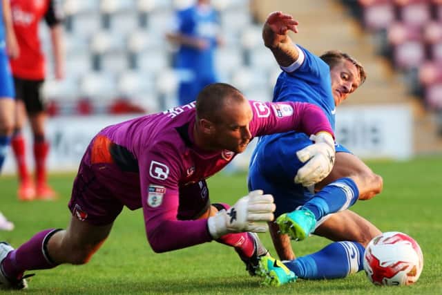 Morecambe goalkeeper Barry Roche rushes off his line to deny Carl Baker Picture: Joe Pepler