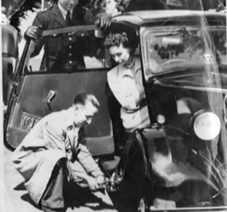 Gladys Howard, a future lord mayor of Portsmouth, getting help from a mechanic.