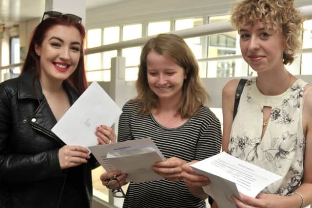 Jessica Caspall, 19, Jade Samways, 18, and Hannah Buckingham, 18, check their results at South Downs College 
Picture: Mick Young
 (161080-03)