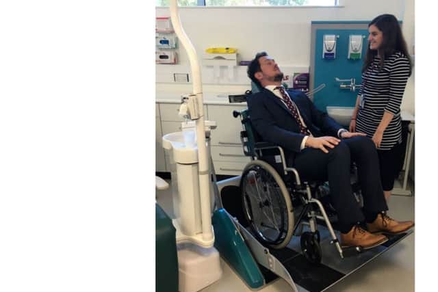 Cllr Stephen Morgan tries out the wheelchair recliner for patients with disabilities at the Somerstown Dental Clinic